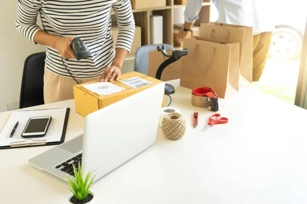 Ecommerce konsepti, ofiste ya da evde çalışarak çevrimiçi sipariş veren müşterilere gönderilmek üzere ürünü kutuda hazırlayın. Barkod tarayıcılı lojistik kutusu