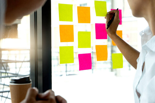 Обратите внимание на расписание на бумаге. Деловые люди встречаются и используют его записи для обмена идеями. Обсуждение - бизнес
,