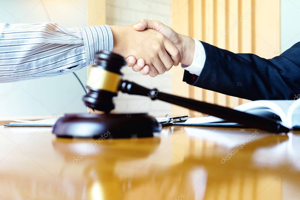 Lawyer or judge gavel with balance handshake with client 