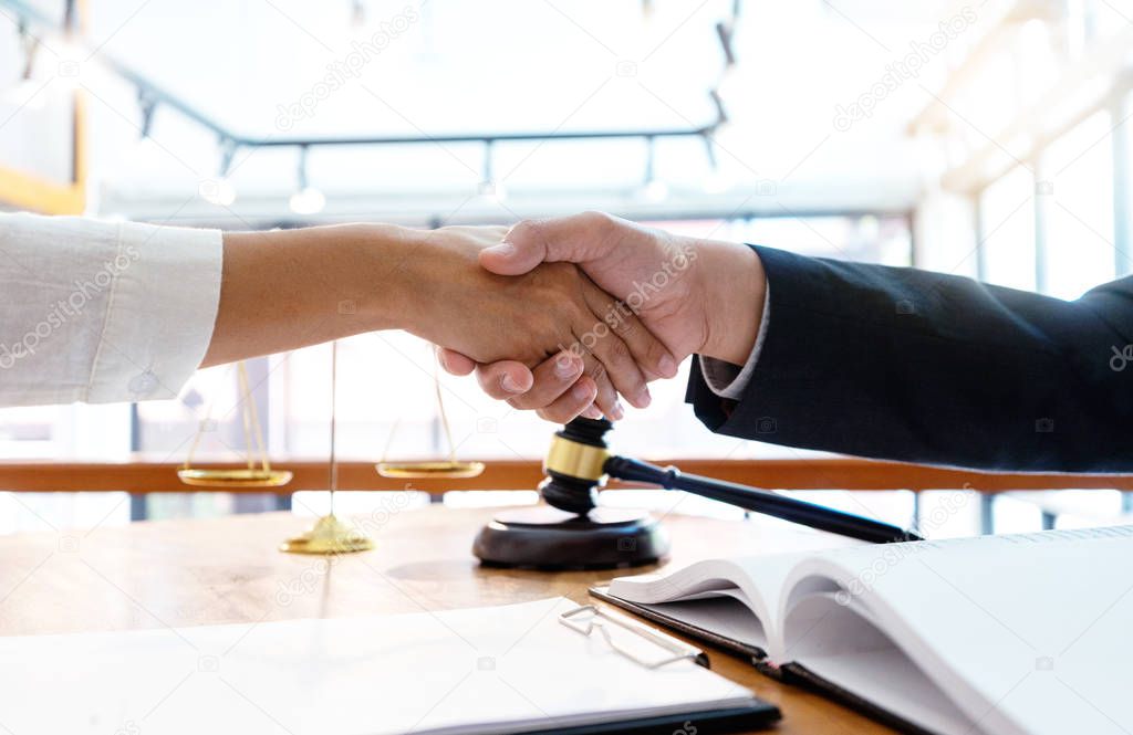 Lawyer or judge  with gavel and balance handshake with client 