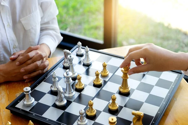 Two businesswoman thinking and hold king chess