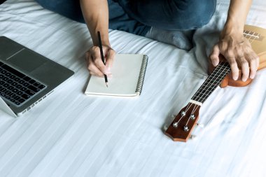 Genç adam bir şarkı ya da müzik yazıyor. 