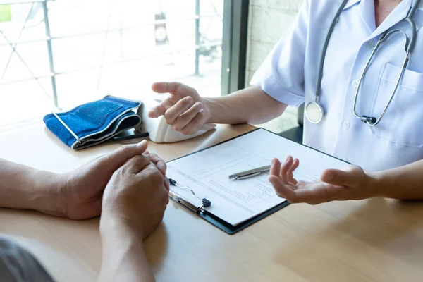 professional doctor sit at the table and talk to the patient