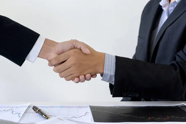 Empresário apertar a mão na mesa de escritório entre computador — Fotografia de Stock