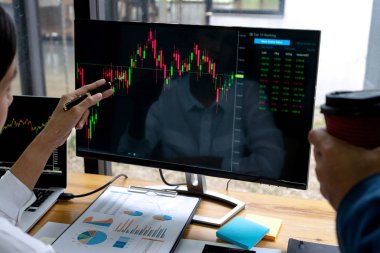 İş adamı diğer masada oturup bilgisayara bakar.