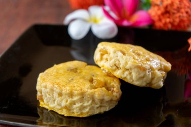 İki çörekçi doğayla iç içe. Arka planda renkli çiçekler var.