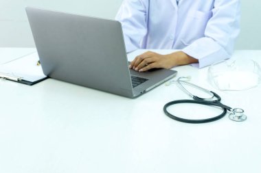 Doktorun masasında bir defter ve yüz maskesi gözlüğü var. Virüs salgını sırasında Corona Covid 19.