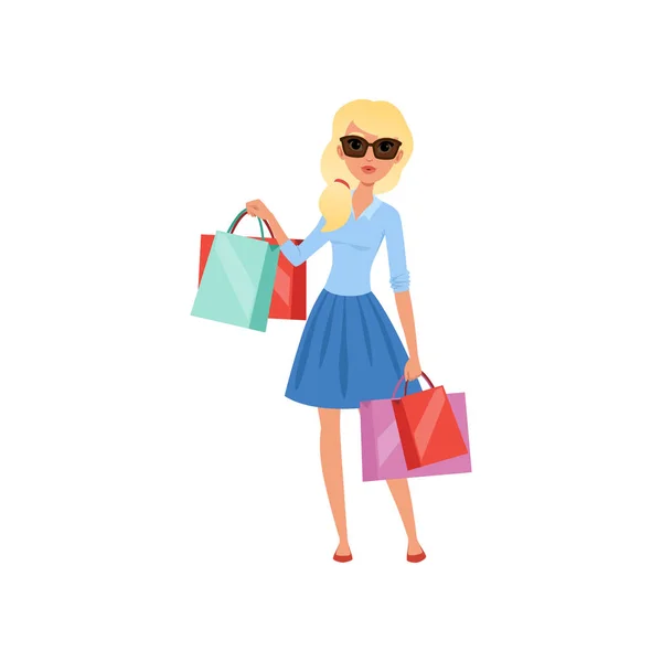 Młoda blond dziewczyna posiadających wiele kolorowe torby na zakupy. Ładna kobieta w okulary, niebieska bluzka i spódnica. Wektor Płaska konstrukcja — Wektor stockowy