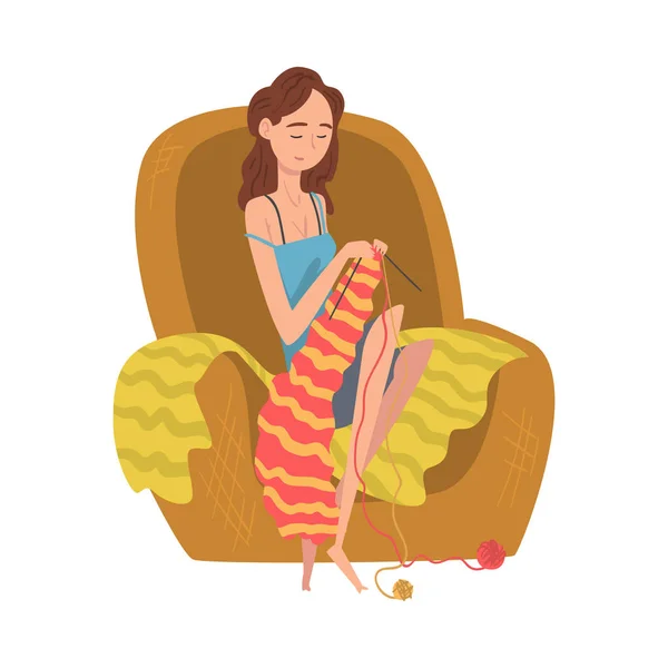アームチェアと編み物に座る若い女性、日常生活のベクトルイラストの女の子 — ストックベクタ