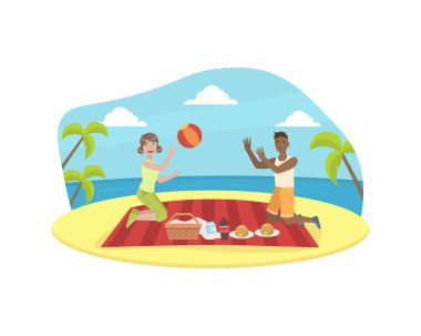 Mutlu çift piknik yapıyor ve top oynuyor, Genç adam ve kadın yaz tatilinde tropikal plajda piknik yapıyorlar.