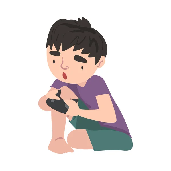 Niño lindo sentado en el piso con Joystick, Niño adolescente jugando video juego estilo de dibujos animados Vector Ilustración — Archivo Imágenes Vectoriales