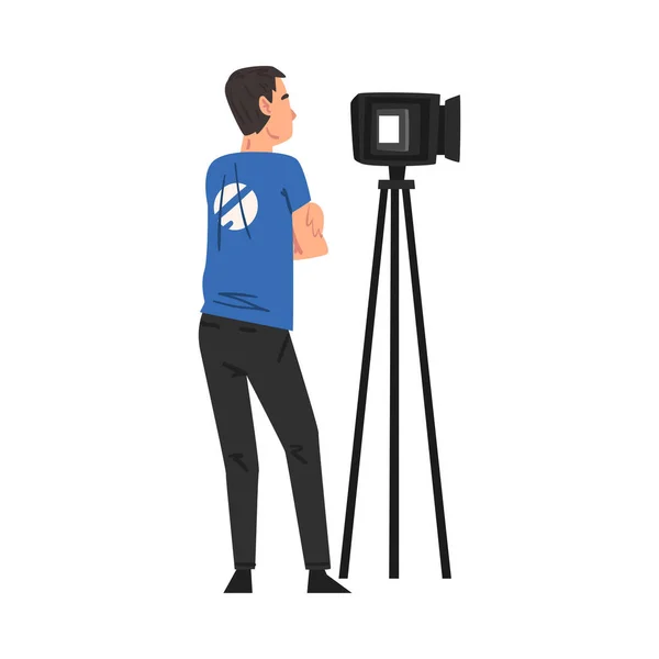 ( 영어 ) Male Video Operator Looking Through Professional Camcorder on Tripod, Television Industry Concept Cartoon Style Vector Illustration — 스톡 벡터