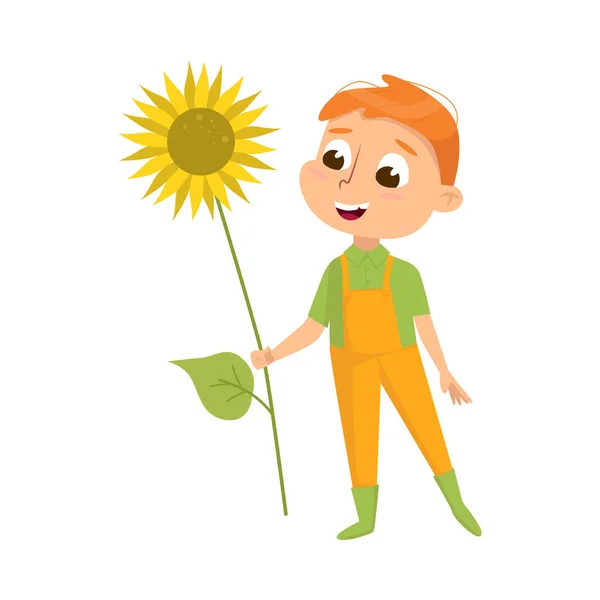 Cute Boy with Sunflower, Little Kid Farmer Character in Overalls Working in Garden Cartoon Style Vector Illustration — Stock Vector