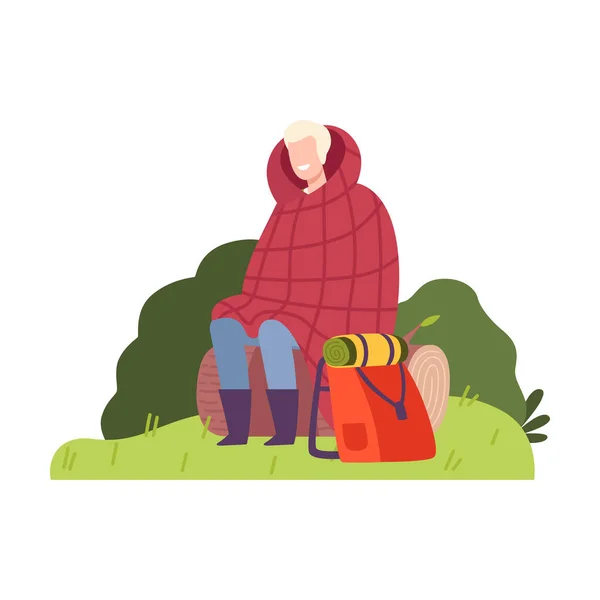 Cheerful Man Wrapped in Blanket and Sitting on Log with Backpack Vector Illustration — Stock Vector