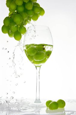 Yeşil üzüm cam içine su sıçrama ile. Beyaz arka plan