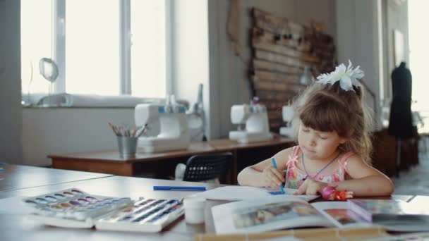 Slide tiro de menina em sorteios com marcadores coloridos na mesa no quarto — Vídeo de Stock