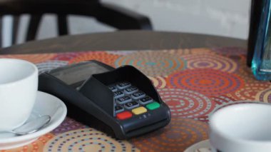 Kafedeki iş kadını bunun bedelini akıllı telefon ve terminal kullanarak ödüyor.