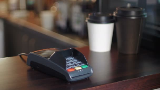 Vista corta de Young Man en la cafetería está pagando el precio mediante el uso de un reloj inteligente y terminal — Vídeos de Stock