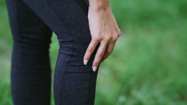Entrenamiento lesiones de aptitud mujer joven con dolor en los músculos de las piernas durante el ejercicio al aire libre — Vídeo de stock