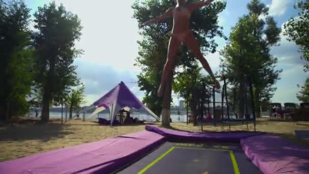 Mulher se divertindo no trampolim na praia — Vídeo de Stock