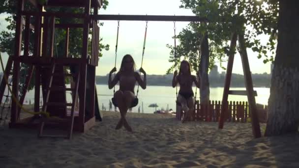 Junge Frauen entspannen auf der Schaukel am Strand — Stockvideo