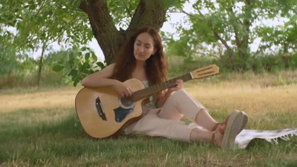 Jong mooi meisje spelen akoestische gitaar — Stockvideo