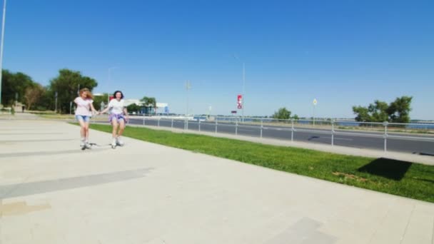 Jovens meninas bonitas patinando em um parque . — Vídeo de Stock