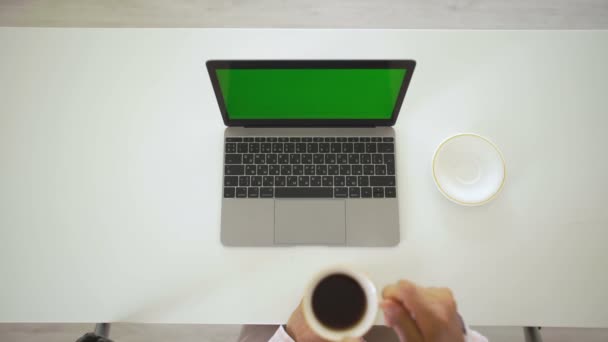 Vrouw werkt aan haar laptop en drinkt koffie — Stockvideo