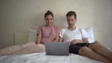 Çift komik film izlemek için bilgisayar kullanıyor.