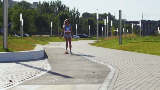 Ragazza in pantaloncini corti cavalcando uno skateboard — Video Stock