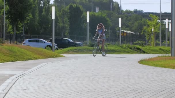 Junges Mädchen fährt Fahrrad im Park — Stockvideo