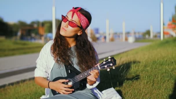 Jong mooi meisje spelen ukelele gitaar — Stockvideo