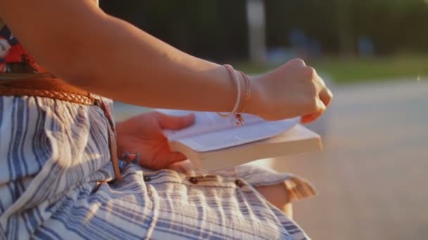 Close up de mulher está lendo livro no parque da cidade . — Vídeo de Stock