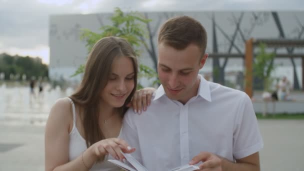 Portrait of couple students are reading book in park — Stock Video