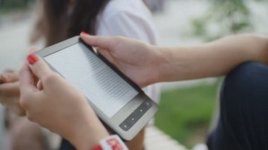 Kadınların elleri kitapla parkta