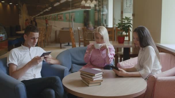 Amigos estão bebendo café e lendo ebooks no café — Vídeo de Stock
