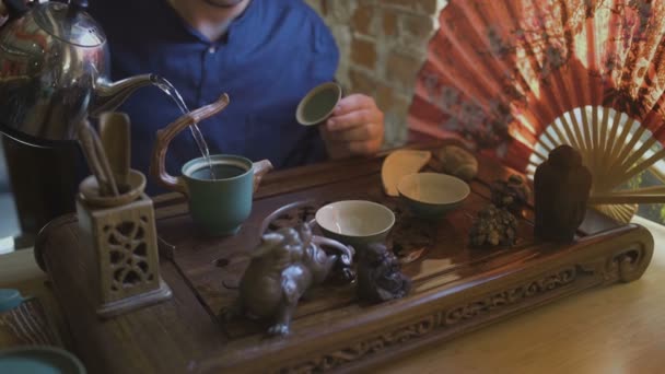 O homem derrama água quente numa chaleira. Cerimônia de chá chinês — Vídeo de Stock