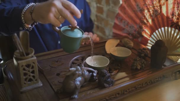 Slide Shot of Man Versare il tè verde dalla teiera a Gaiwan alla cerimonia tradizionale cinese del tè . — Video Stock