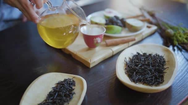 Frau gießt grünen Tee aus Teekanne in Tasse — Stockvideo