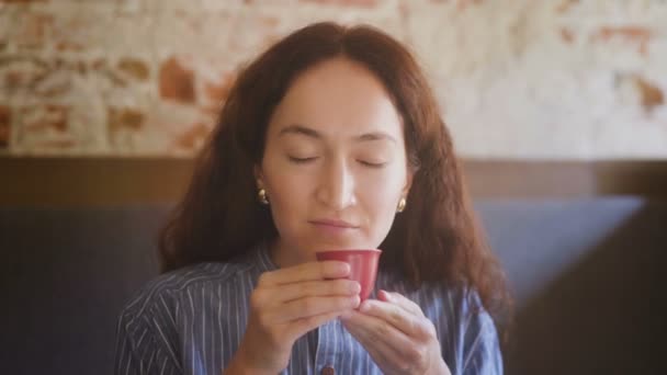 Женский портрет пьет чай из красной чашки — стоковое видео