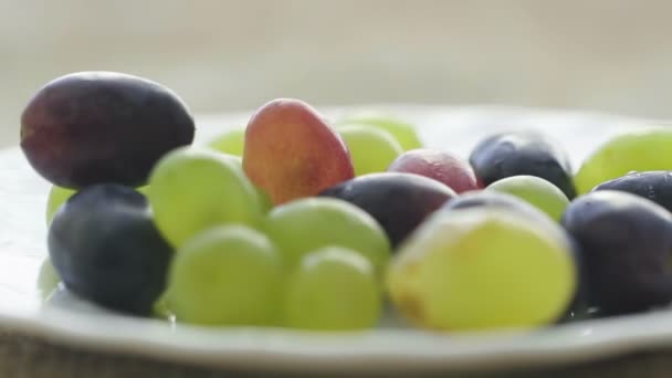 Uvas blancas y oscuras en un plato — Vídeos de Stock