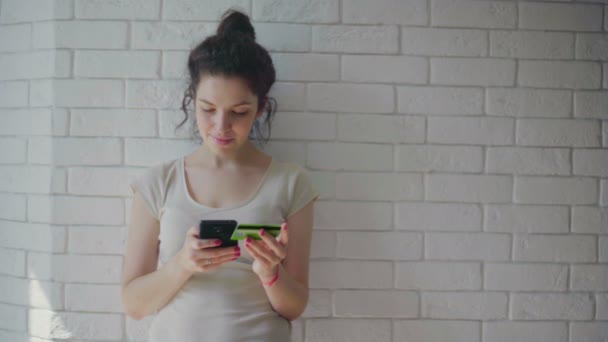 Mooie vrouw winkelen online met credit card met behulp van smartphone thuis. — Stockvideo