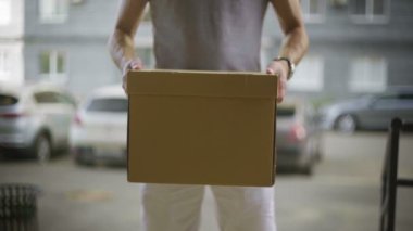 Postacı paketi kameraya verir.