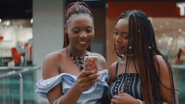 Två söta afrikanska kvinnor vänner med shoppingväskor — Stockvideo