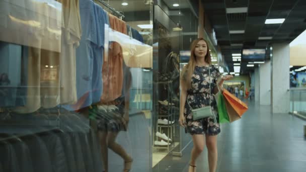 Asiatisk flicka kommer ut ur affären — Stockvideo