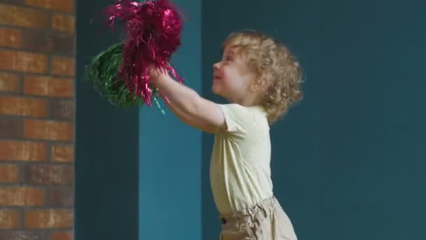 Little Cheerleader is laying with pompoms — Stock Video