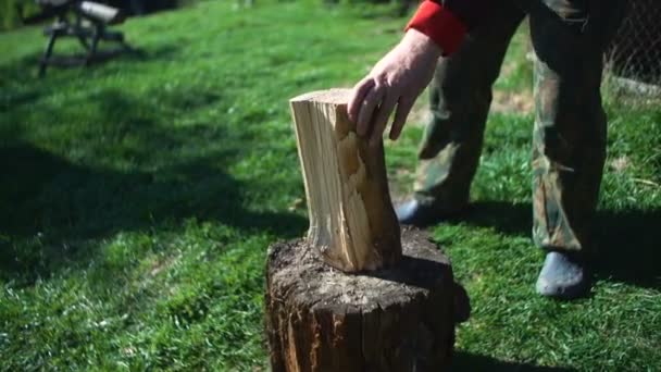 Un hombre con un hacha cortando madera — Vídeo de stock