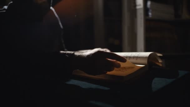 Monk sta leggendo un vecchio libro al buio — Video Stock