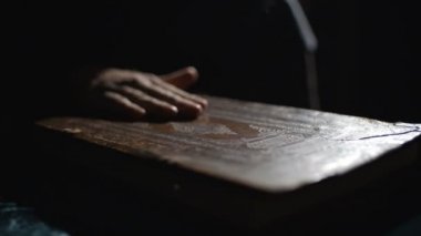 Birisi kitabın tozunu alıyor.