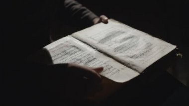 Birisi eski kitapta bir şey arıyor.